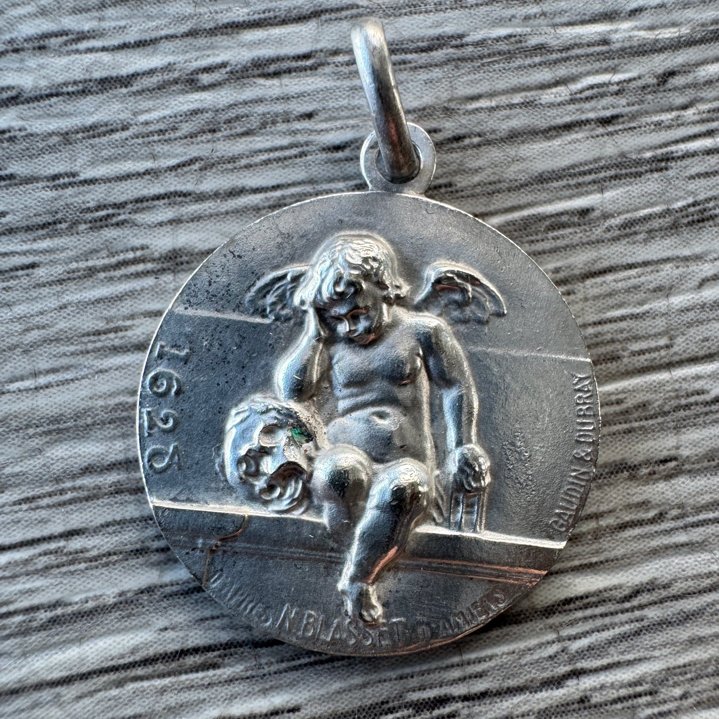 Médaille religieuse ancienne « Angelot accoudé sur un crâne »